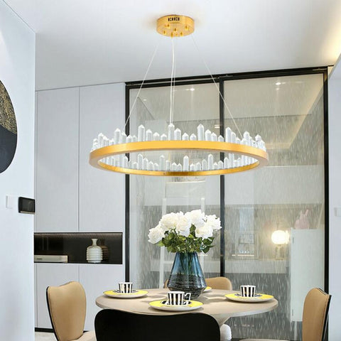 round gold chandelier with crystal obelisks over breakfast table