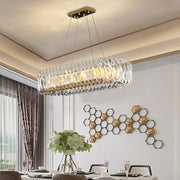 oval chandelier with crystal spirals and crystal rectangular prisms hanging from a gold rectangular canopy with adjustable wires in dining room