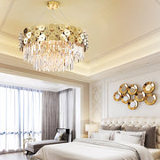 round crystal chandelier with gold discs in bedroom