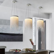 three silver fringe pendant lights over dining room table