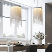two silver fringe pendant lights over dining room table