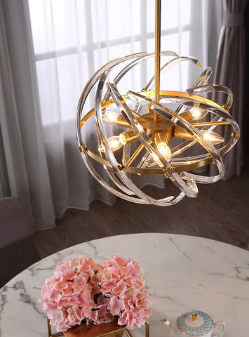 Gorgeous gold pendant light with woven crystal adornment illuminated hanging over small table set for tea