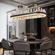 oval gold chandelier with leather bank and obelisk shaped crystals over gray dining room 