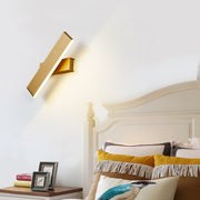 contemporary diagonal LED wall sconce next to bed over nightstand