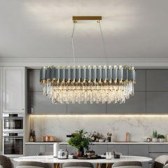 rectangular crystal chandelier gun metal gray and gold body illuminated in luxury kitchen