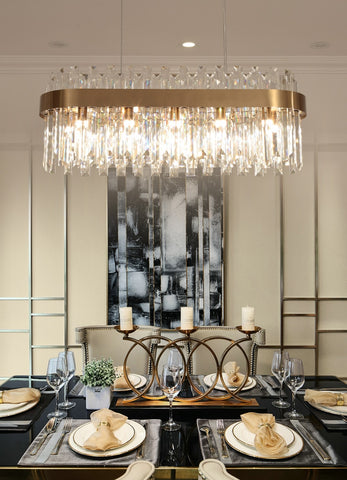 oval crystal chandelier illuminated suspended over dining room table