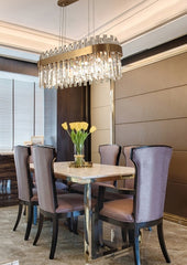 oval crystal chandelier illuminated suspended over dining room table