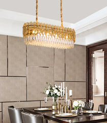 oval champagne crystal chandelier suspended over elegant dining room table