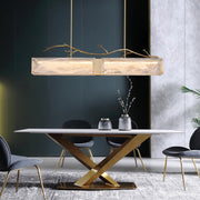 rectangular glass chandelier with cloud texture and copper branch on top over modern dining table