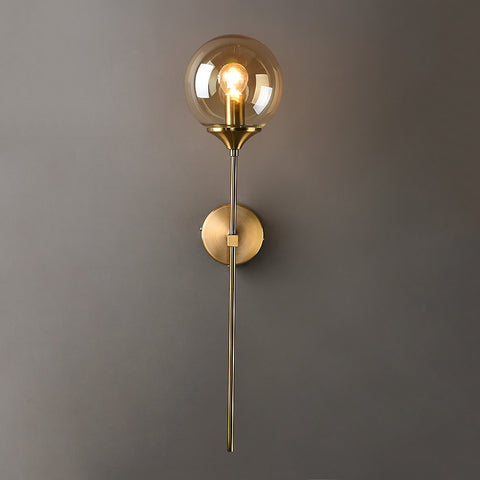 long wall sconce in gold with tinted glass globe