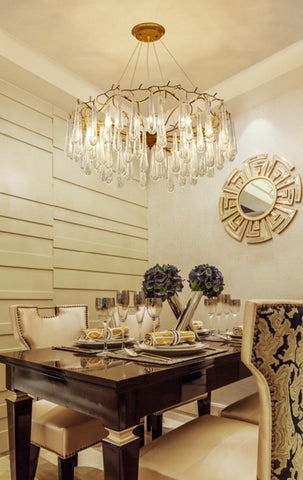 round contemporary gold branch chandelier with clear water drop crystals over dining table